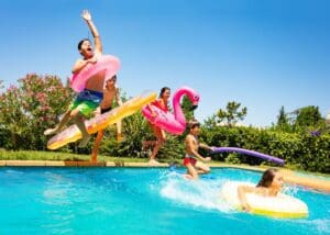 Happy,Friends,Jumping,In,Pool,On,The,Vacations