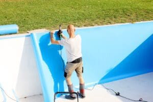 A,Worker,Welds,Plastic,Cover,For,Water,Pool.,Water,Pool