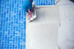 Worker,Laying,Tile,In,The,Pool.,Pool,Repairing,Work.