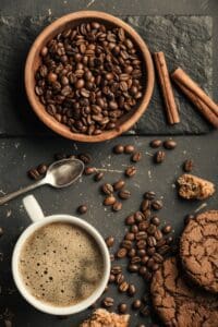 Black,Fried,Coffee,Beans,In,Cafe,With,Cookie,And,Cake