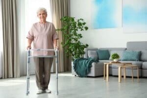 Elderly,Woman,Using,Walking,Frame,Indoors.,Space,For,Text