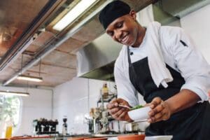 Gourmet,Chef,In,Uniform,Cooking,In,A,Commercial,Kitchen.,Happy