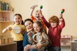 Excited,Multiethnic,Kids,Playing,Musical,Instruments,Near,Happy,Teacher