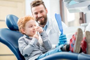 Young,Excited,Boy,Looking,At,The,Dental,Mirror,Sitting,On