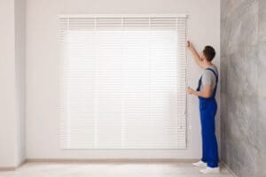 Worker,In,Uniform,Opening,Or,Closing,Horizontal,Window,Blind,Indoors