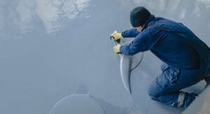 The,Worker,Applies,Gray,Epoxy,Resin,To,The,New,Floor