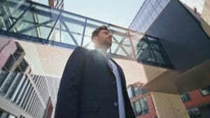 Business owner standing street under sunlight. Young leader posing near office